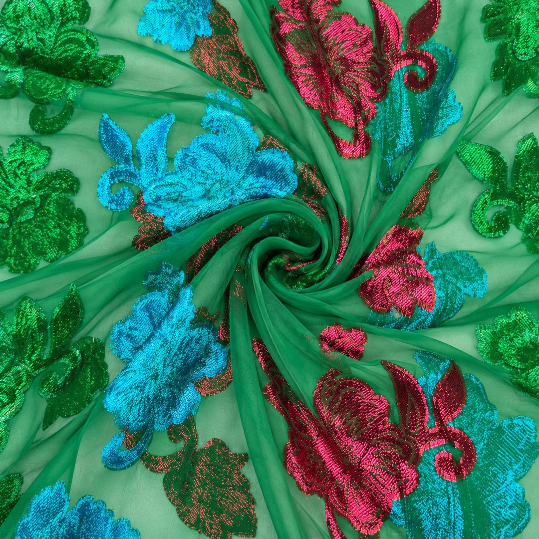 Grøn lurex chiffon med farverige blomstermotiver – stoffet formet som en spiral (billede 1 af 3)