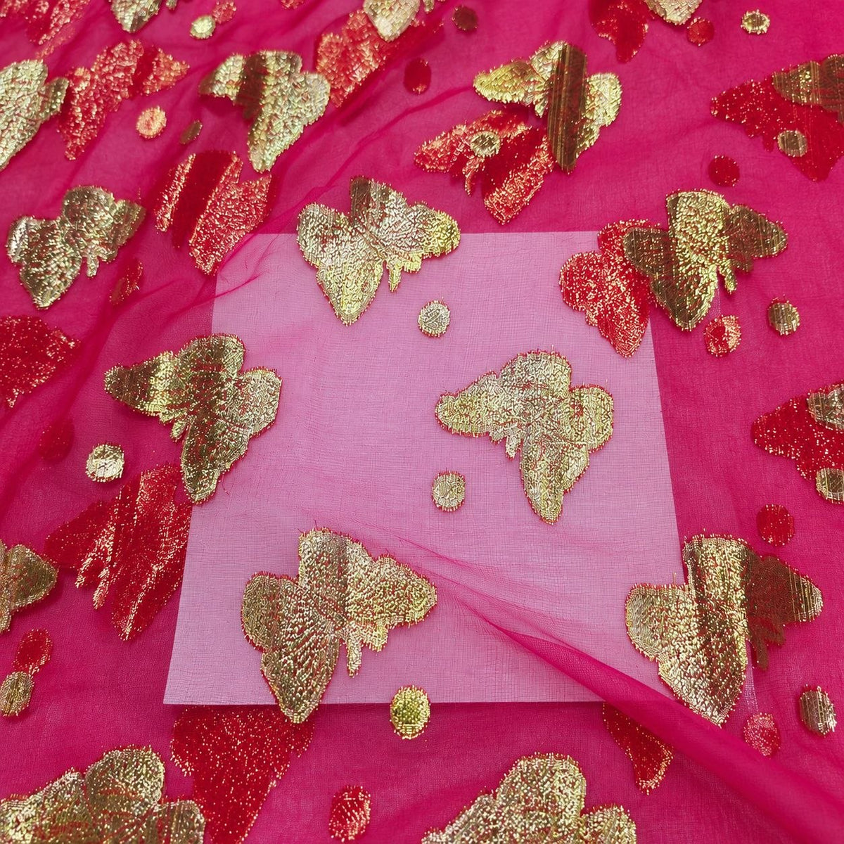 Fuchsia lurex chiffonsilk – nærbillede af sommerfuglemotiverne, prikkerne og stoffets gennemsigtighed (billede 3 af 3)
