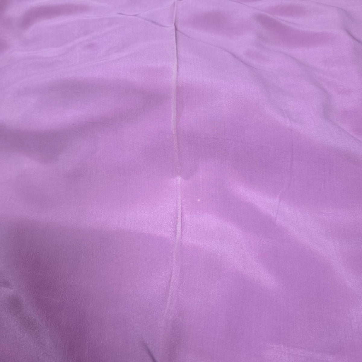 Originalbillede af lavendelfarvet silke georgette – 2. sortering, der viser ujævnheder og et mærke i stoffet (billede 3 af 3)