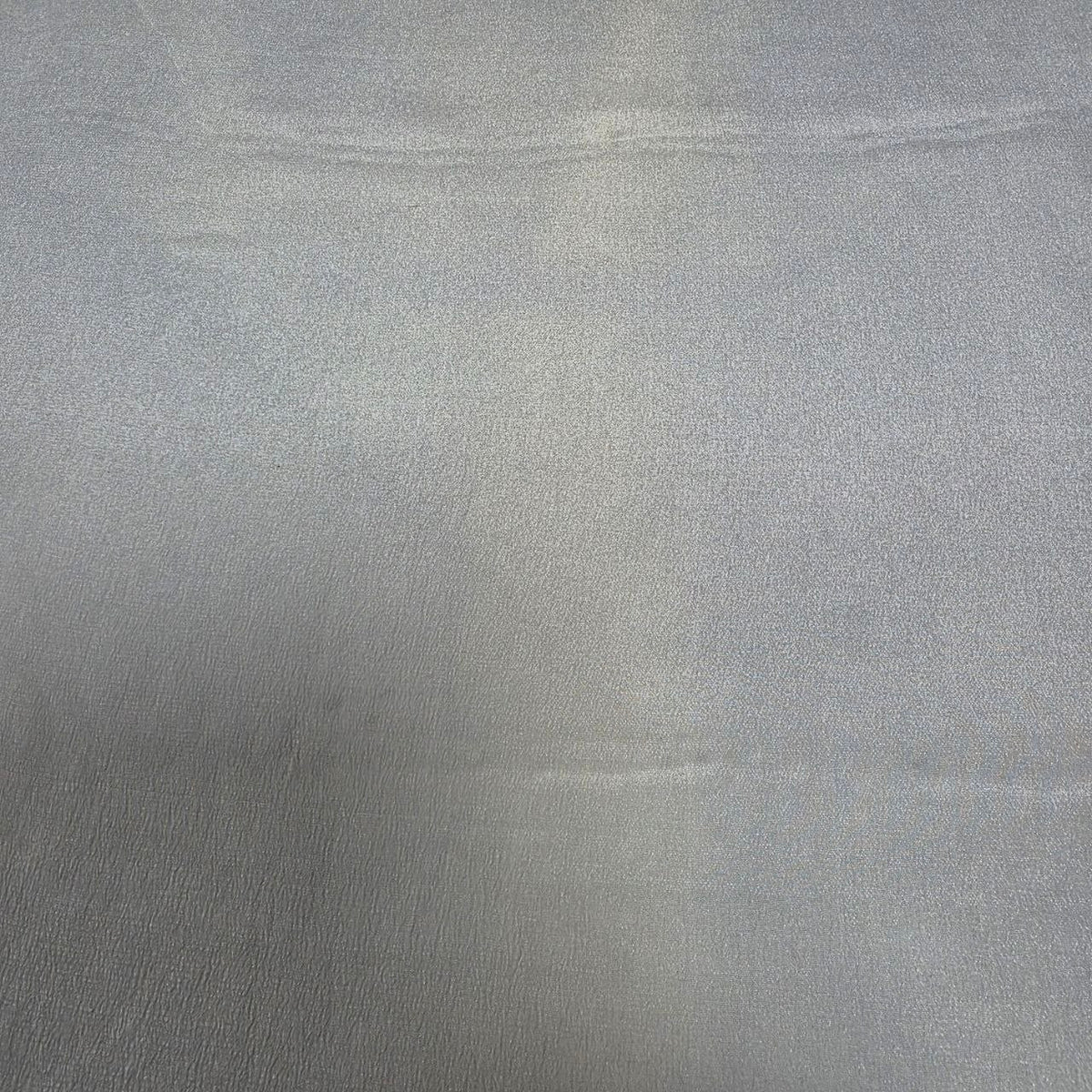 Originalbillede af lysegråt silke georgette – 2. sortering, der viser de synlige vævefejl og ujævnheder i stoffet (billede 3 af 3)
