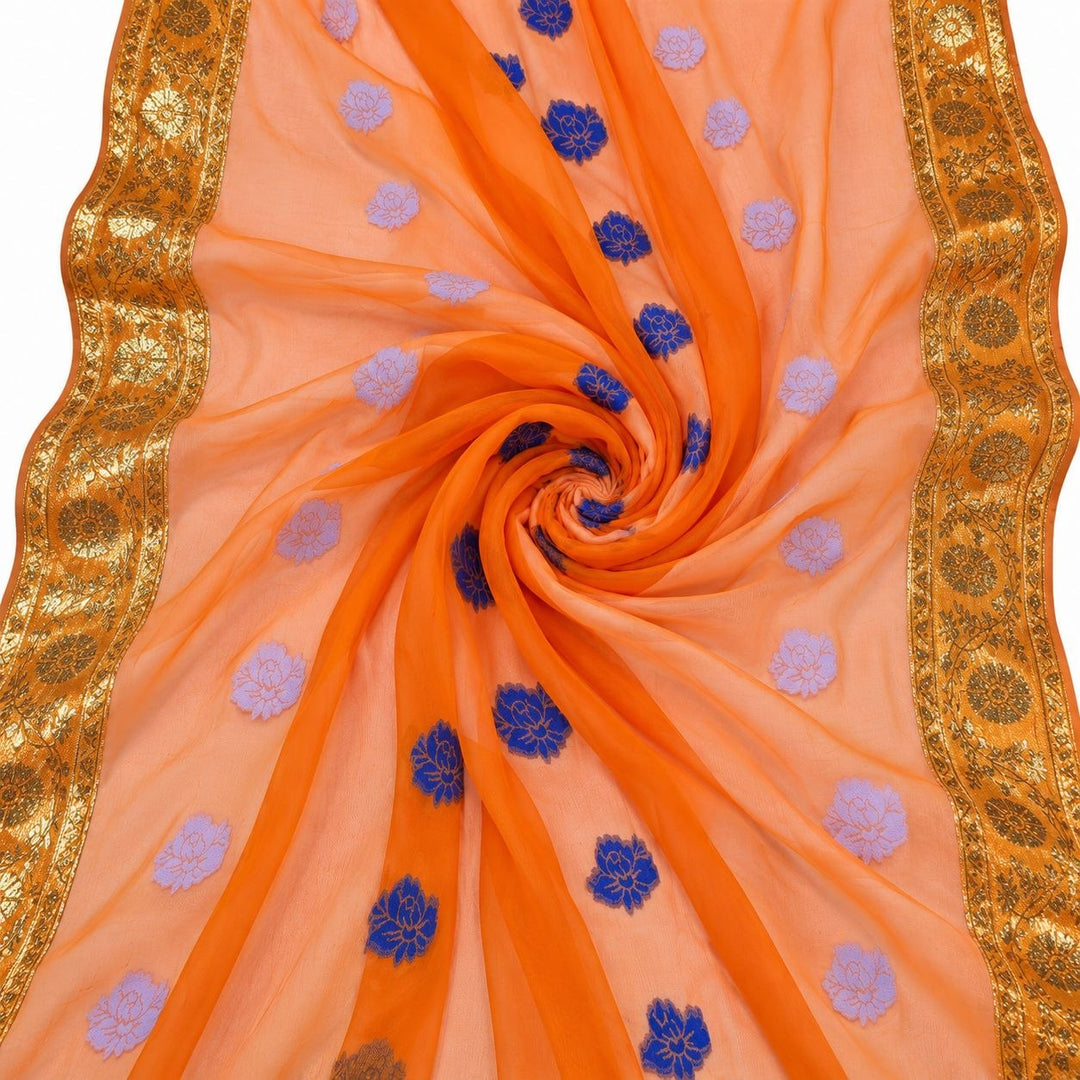 Orange lurex chiffonsilk med blå og lyslilla blomstermotiver og guldborter – stoffet formet som en spiral (billede 1 af 3)