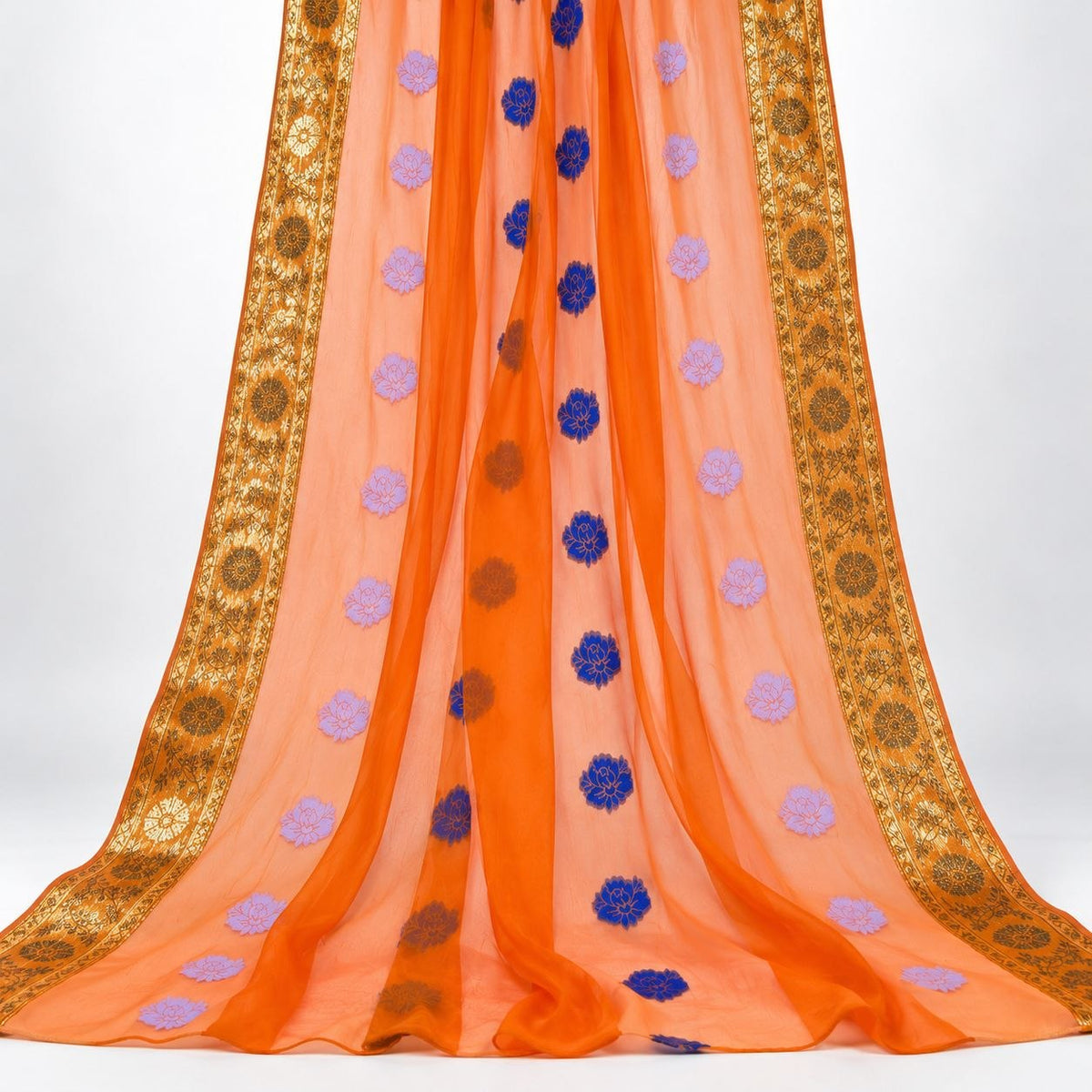 Orange lurex chiffonsilk med blomstermotiver – hængende i bløde folder, guldborterne langs begge sider synlige (billede 2 af 3)