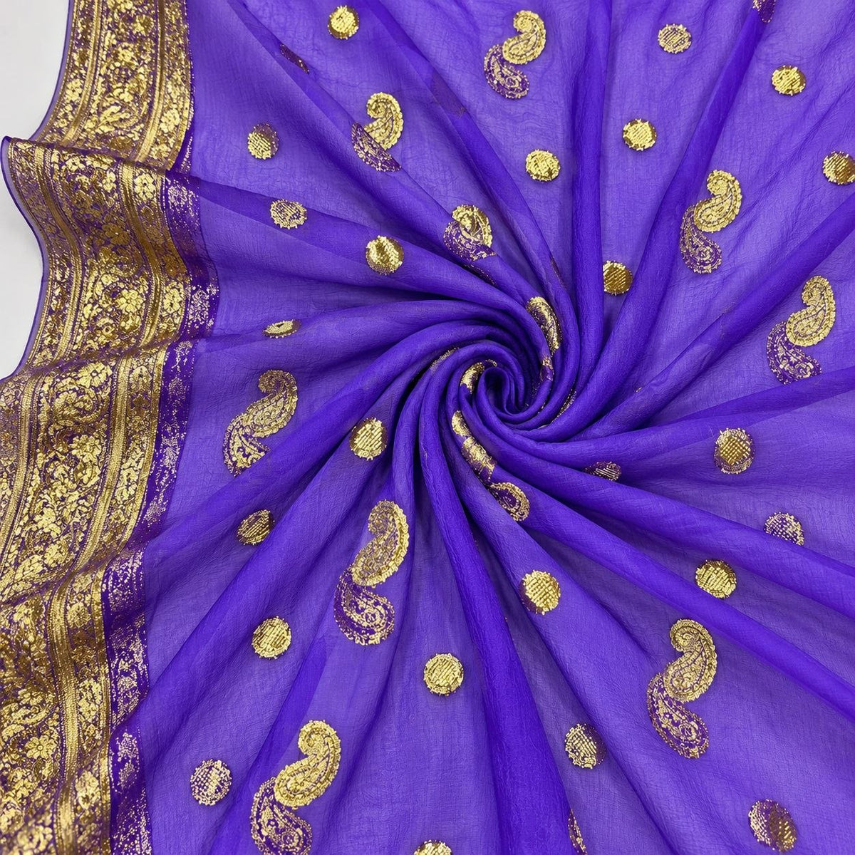 Lilla lurex chiffonsilk med gyldne paisleymotiver og guldbort – stoffet formet som en spiral (billede 1 af 3)