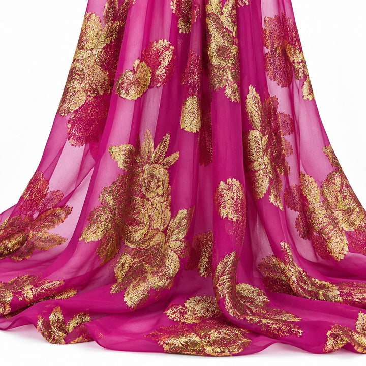 Magenta lurex chiffonsilk med gyldne blomstermotiver – hængende i bløde folder på hvid baggrund (billede 2 af 3)