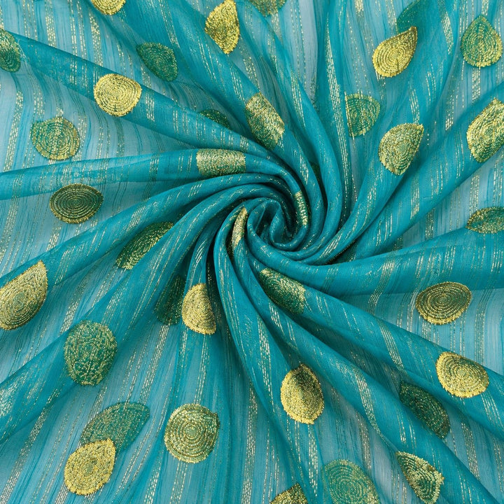 Turkis lurex chiffonsilk med gyldne striber og motiver – stoffet formet som en spiral (billede 1 af 3)