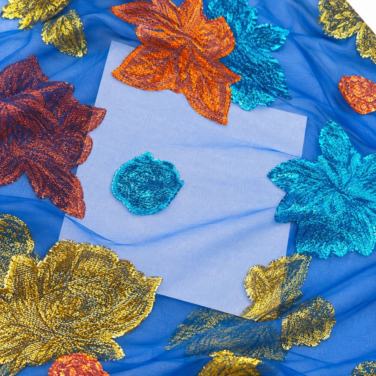 Kongeblå lurex chiffon med flerfarvede metalliske blomstermønstre – nærbillede af de metalliske mønstre og stoffets gennemsigtighed (billede 3 af 3)