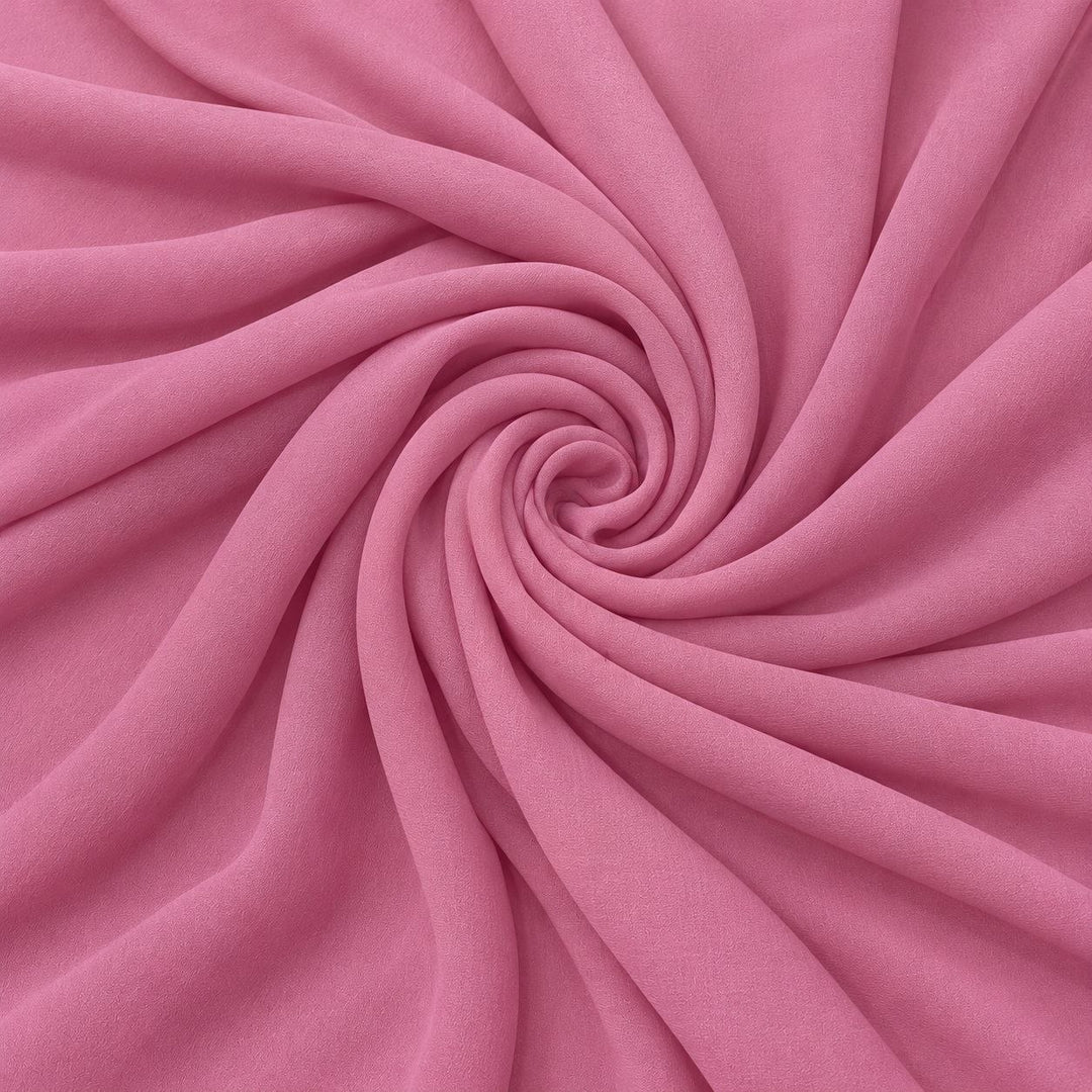 Rosa silke georgette – stoffet formet som en spiral, hvor den creppede overflade ses (billede 1 af 3)