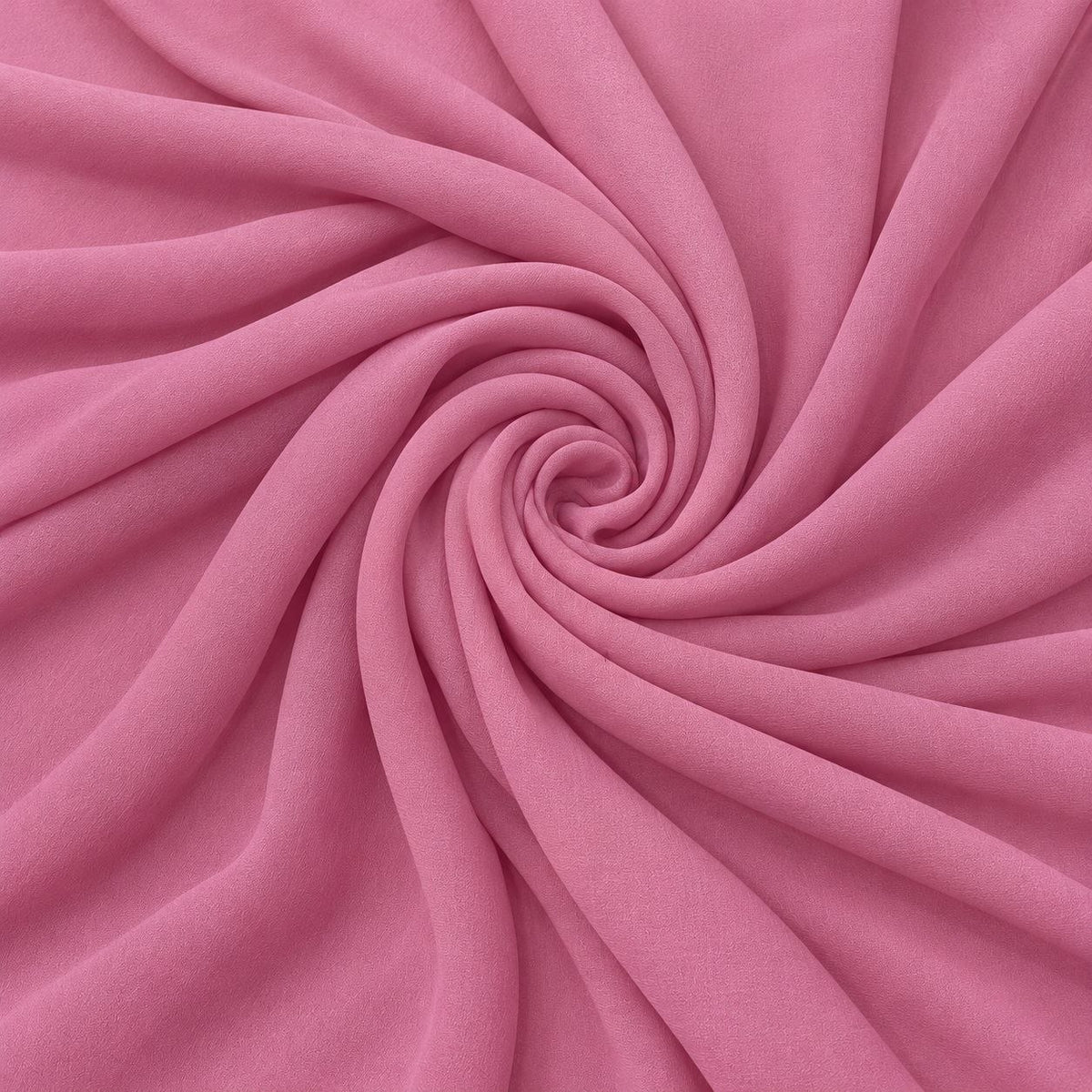 Rosa silke georgette – stoffet formet som en spiral, hvor den creppede overflade ses (billede 1 af 3)