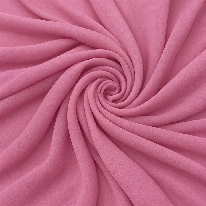 Rosa silke georgette – stoffet formet som en spiral, hvor den creppede overflade ses (billede 1 af 3)