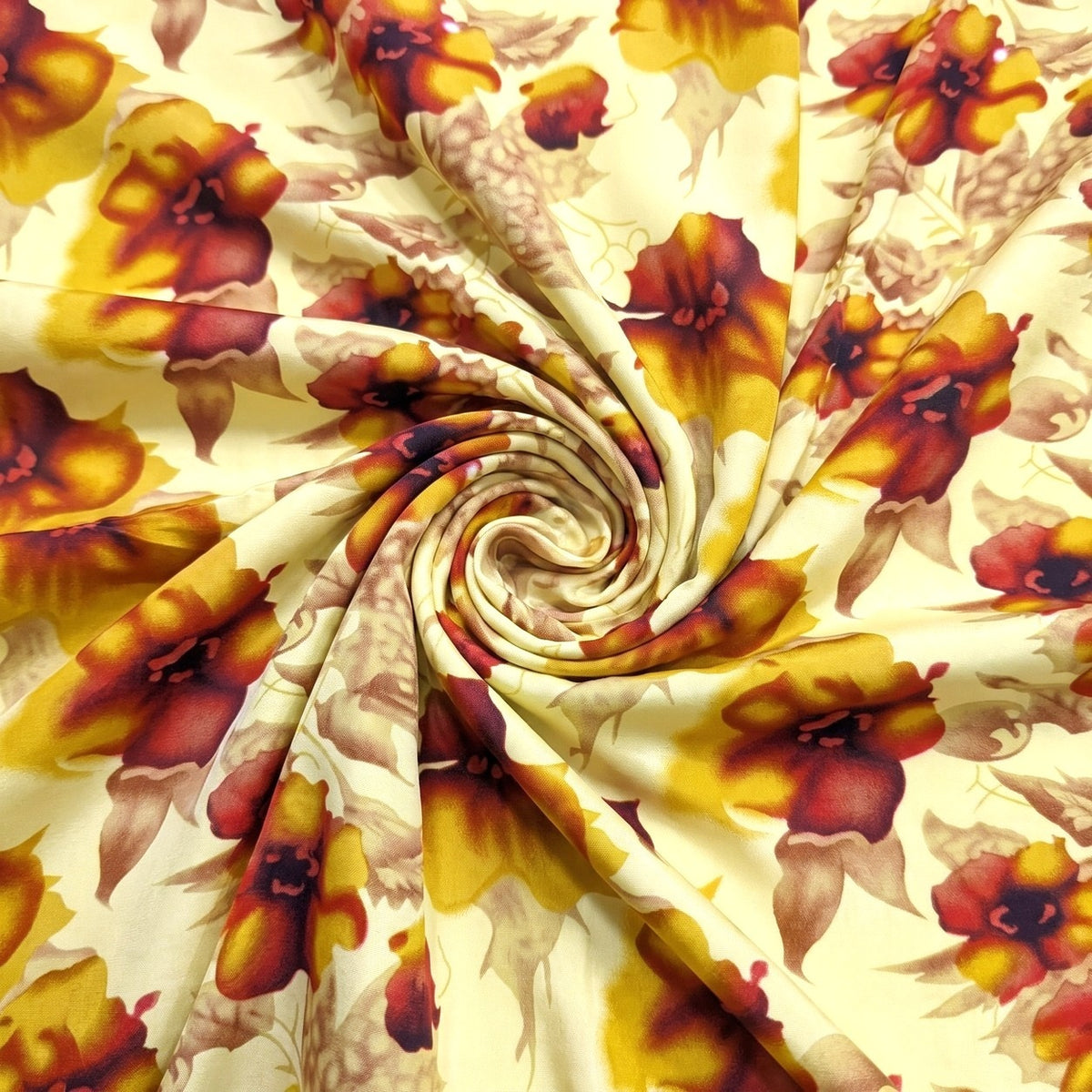BLOMSTRET POLYESTERSTOF – GUL/BORDEAUX – stoffet samlet i en blød swirl, med printet synligt (billede 1 af 3)