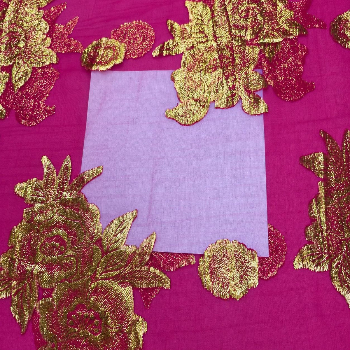Magenta lurex chiffonsilk – nærbillede af blomstermotiverne og stoffets gennemsigtighed (billede 3 af 3)