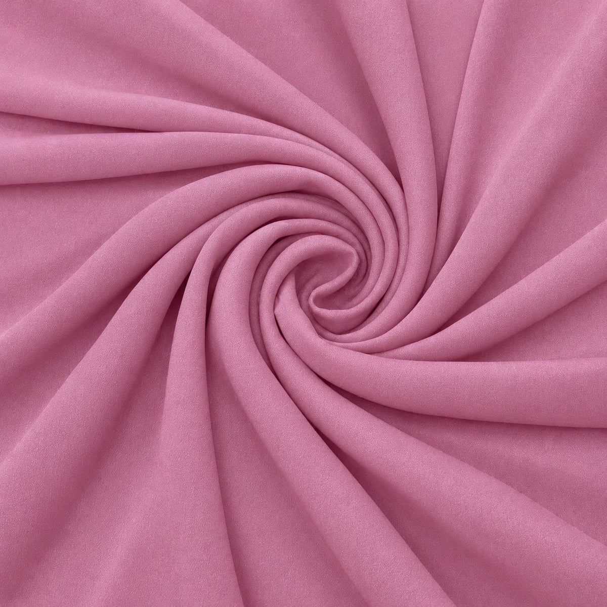 Støvet rosa silke georgette – stoffet formet som en spiral, hvor den creppede overflade ses (billede 1 af 3)