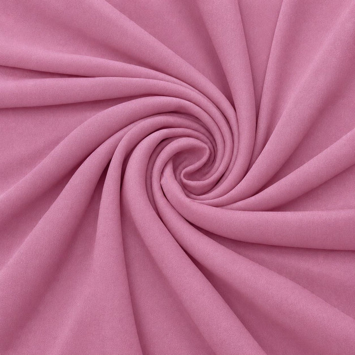 Støvet rosa silke georgette – stoffet formet som en spiral, hvor den creppede overflade ses (billede 1 af 3)