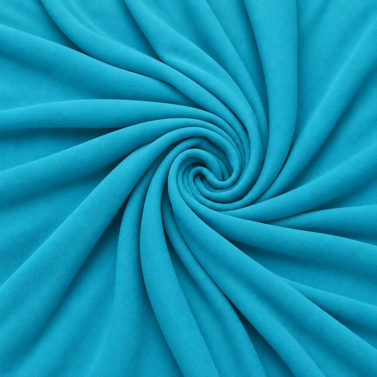 Lys turkisblå silke georgette – stoffet formet som en spiral, hvor den creppede overflade ses (billede 1 af 3)