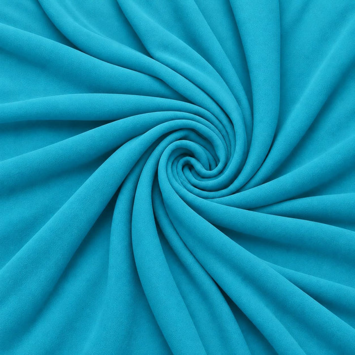 Lys turkisblå silke georgette – stoffet formet som en spiral, hvor den creppede overflade ses (billede 1 af 3)