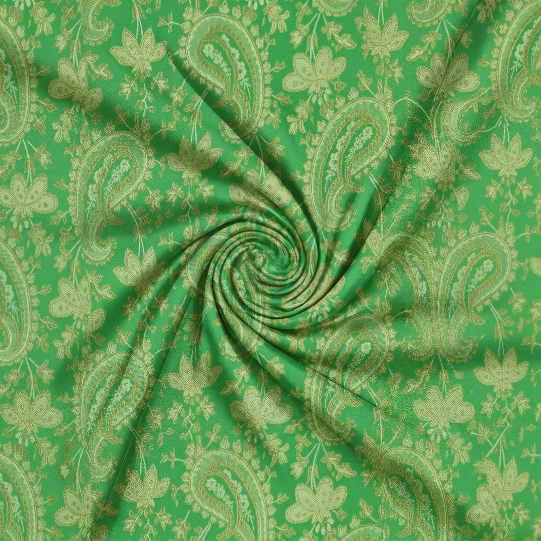 GRØNT SATIN JACQUARD STOF MED BLADE – stoffet samlet i en blød swirl, med det vævede mønster synligt (billede 1 af 3)