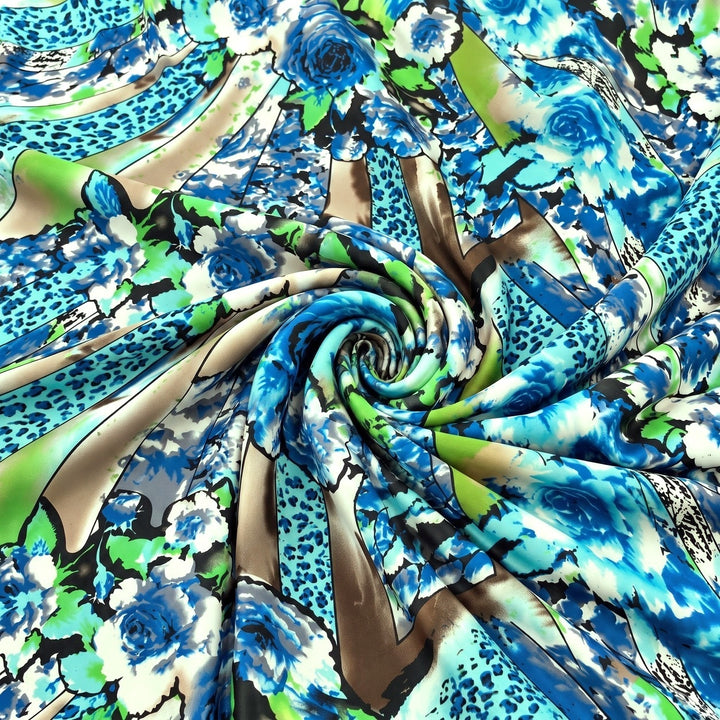 MØNSTRET POLYESTERSTOF – BLÅ/GRØN/BRUN MULTI – stoffet samlet i en blød swirl, med printet synligt (billede 1 af 3)