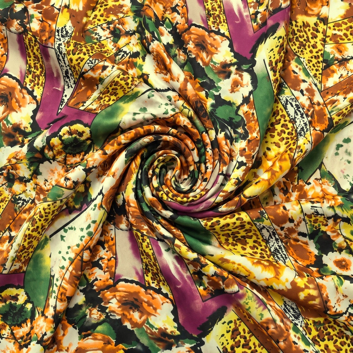 MØNSTRET POLYESTERSTOF – GUL/ORANGE/LILLA MULTI – stoffet samlet i en blød swirl, med printet synligt (billede 1 af 3)