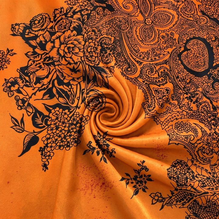 Orange silke med paisleyprint – hele mønstret med pletter synlige – stoffet samlet i en blød swirl, med printet synligt (billede 1 af 4)