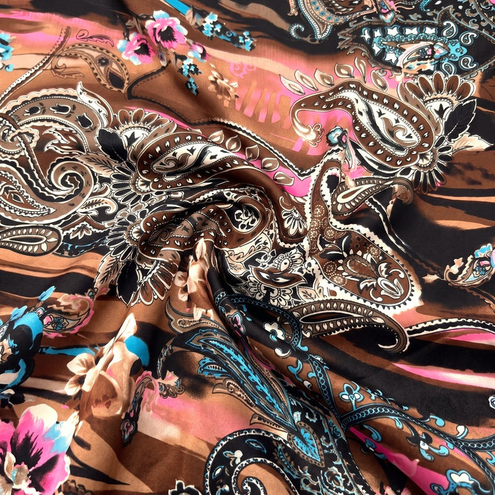 PAISLEY POLYESTERSTOF – BRUN/PINK/TURKIS MULTI – stoffet samlet i en blød swirl, med printet synligt (billede 1 af 3)