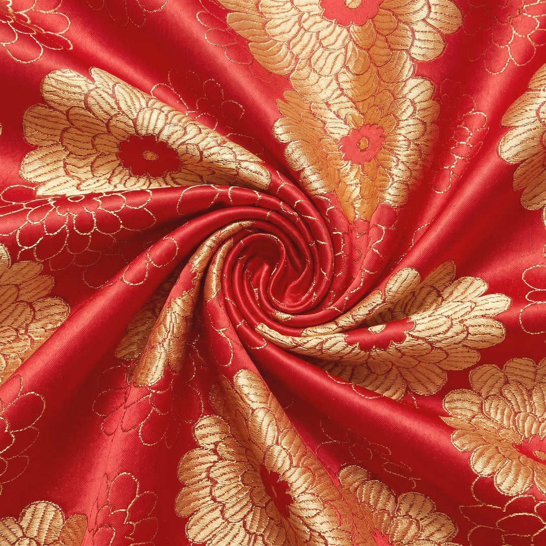 RØD SATIN JACQUARD STOF MED MORGENFRUER – stoffet samlet i en blød swirl, med det vævede mønster synligt (billede 1 af 3)