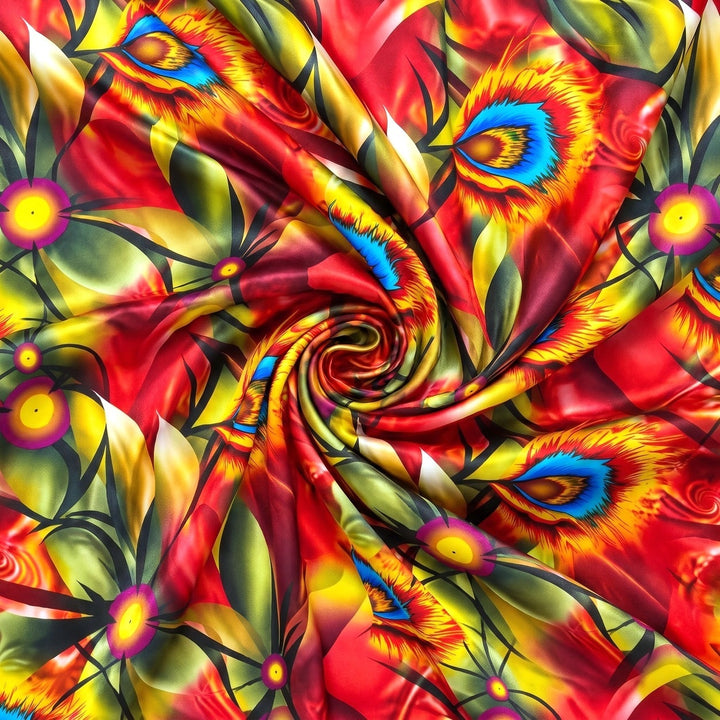 RØD OG GUL SILKE MED FANTASIMØNSTER – stoffet samlet i en blød swirl, med printet synligt (billede 1 af 3)