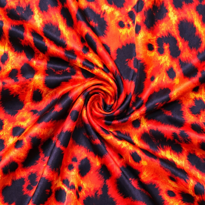 RØD OG ORANGE SILKE M. LEOPARD MØNSTER – stoffet samlet i en blød swirl, med printet synligt (billede 1 af 3)
