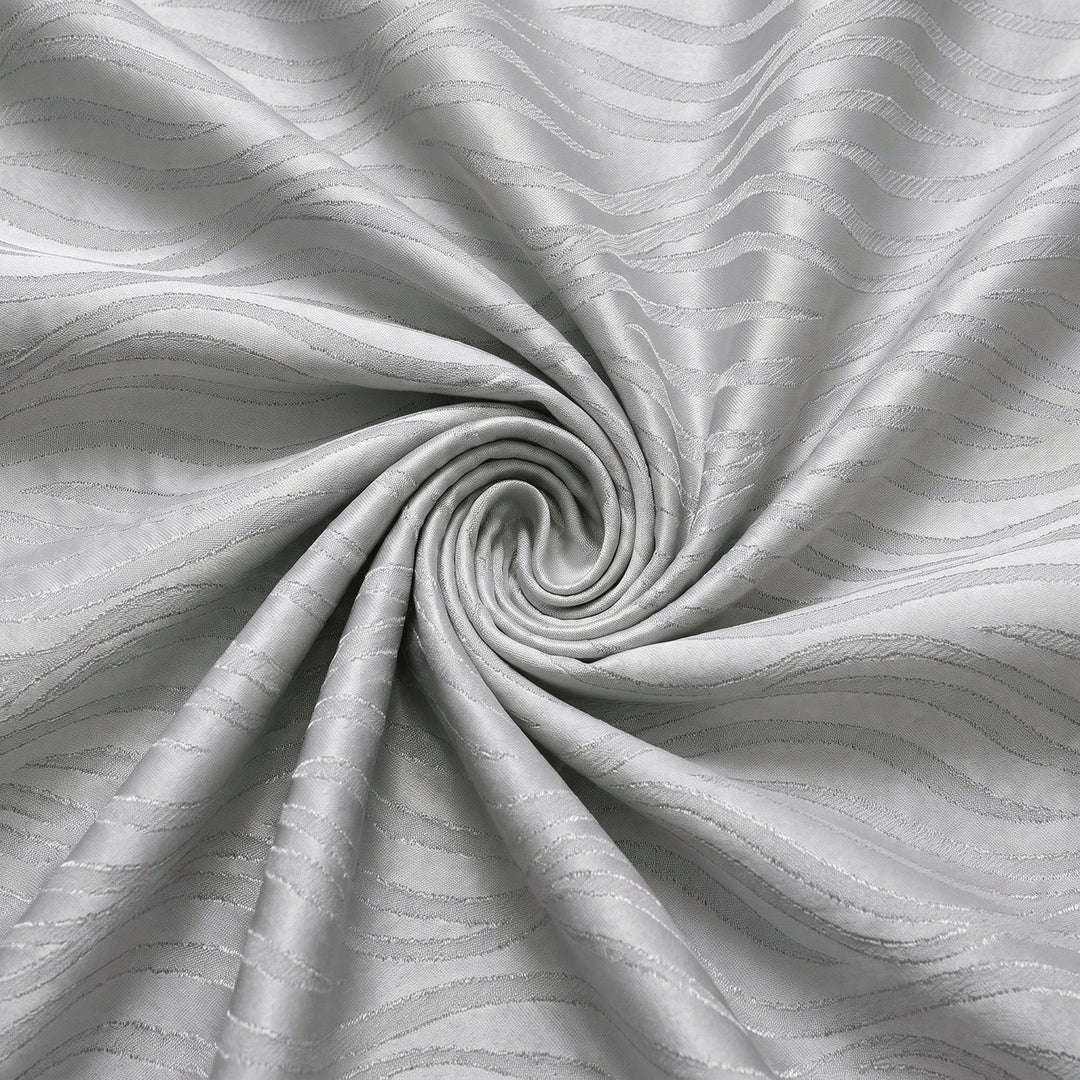 Sølv satin jacquard stof med bølgemønster – stoffet samlet i en blød swirl, med det vævede mønster synligt (billede 1 af 3)