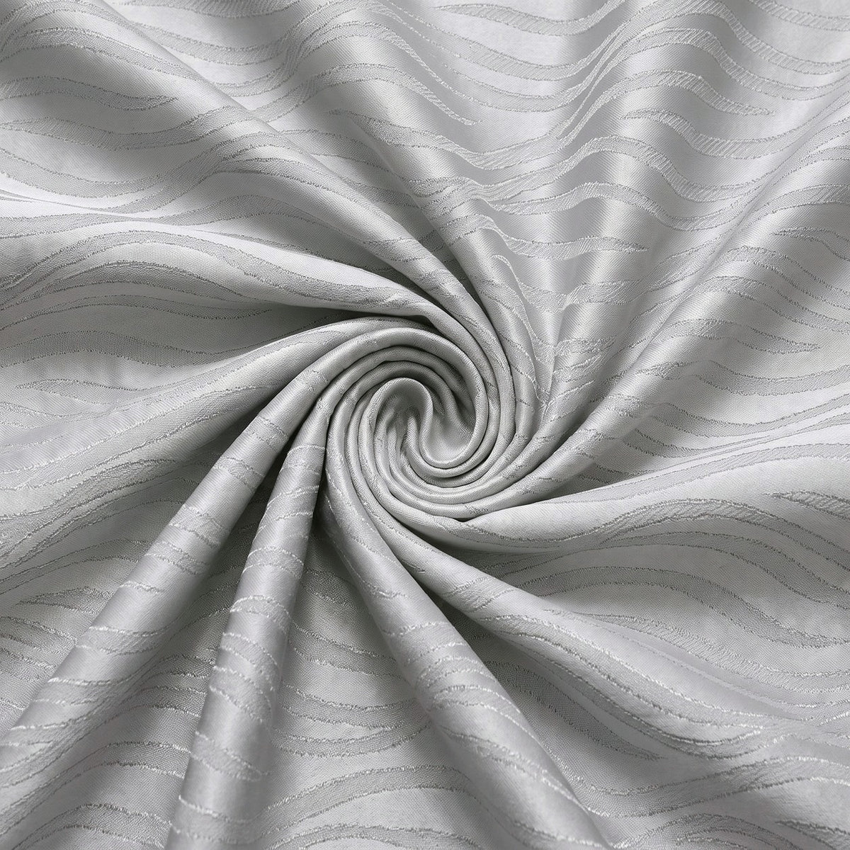 Sølv satin jacquard stof med bølgemønster – stoffet samlet i en blød swirl, med det vævede mønster synligt (billede 1 af 3)