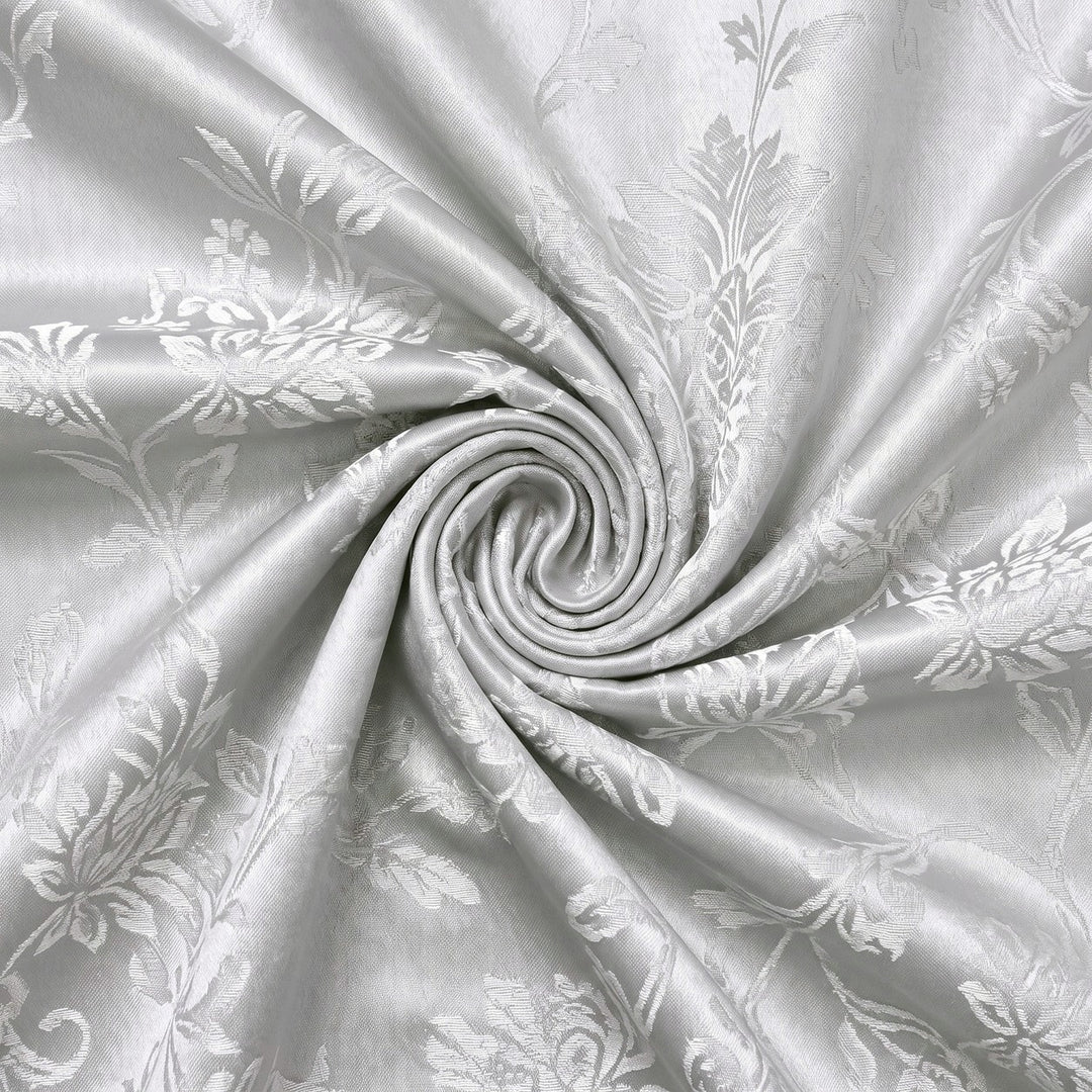 SØLV SATIN JACQUARD STOF MED BLOMSTERRANKER – stoffet samlet i en blød swirl, med det vævede mønster synligt (billede 1 af 3)